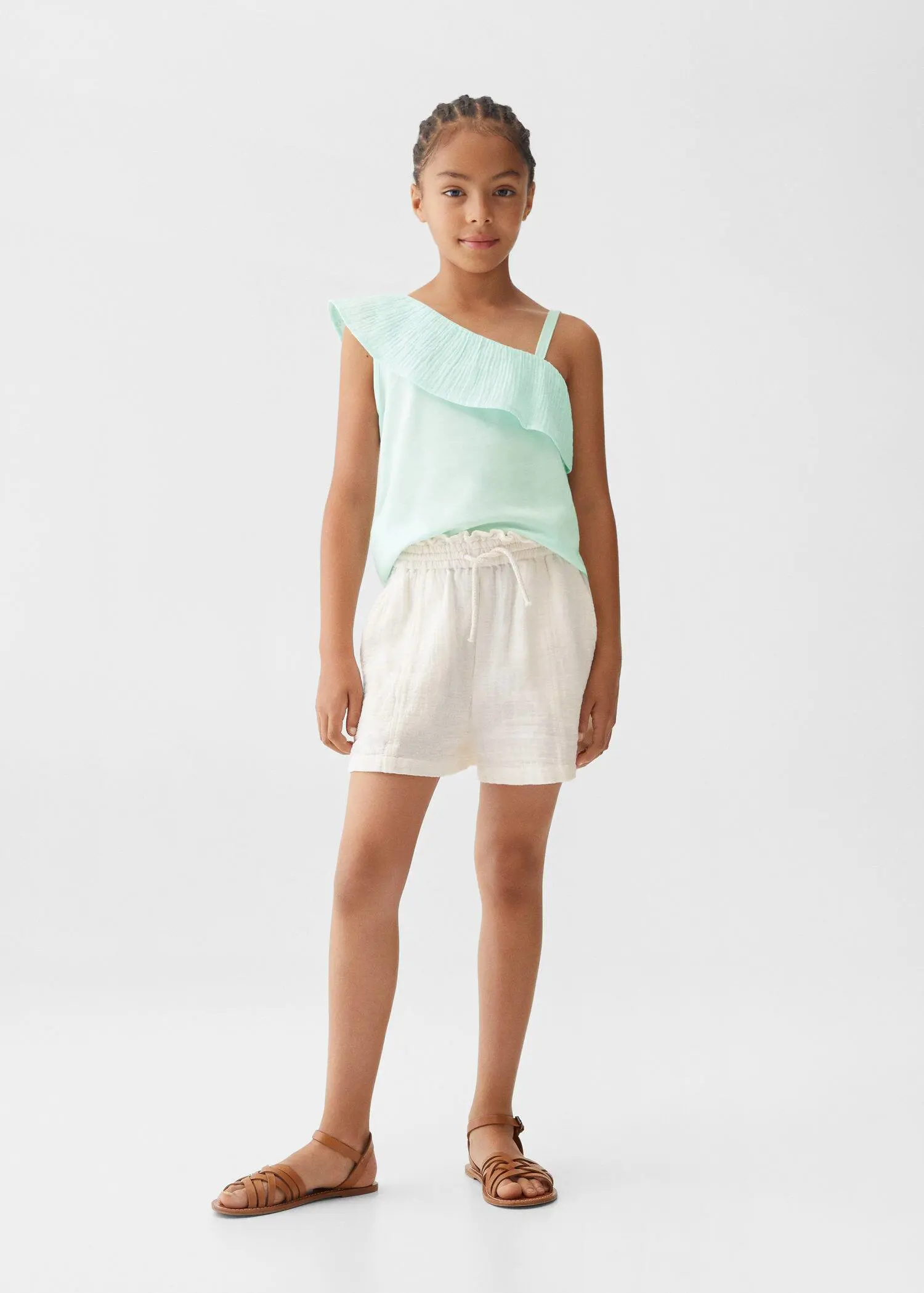 Mango Shorts with gathered detail . a young girl wearing a light blue top and white shorts. 