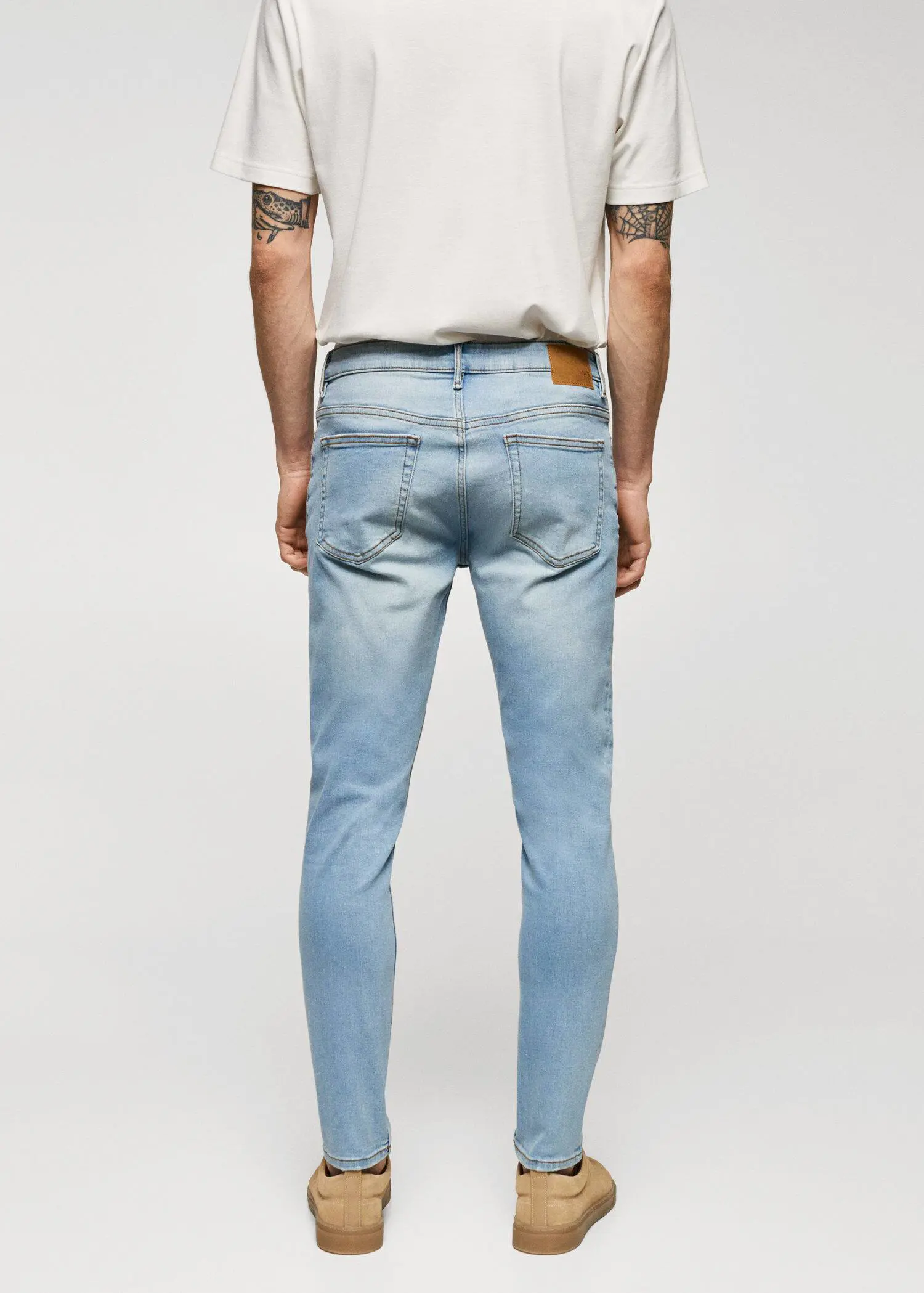 Mango Jude skinny-fit jeans. a person wearing light blue jeans and a white shirt. 