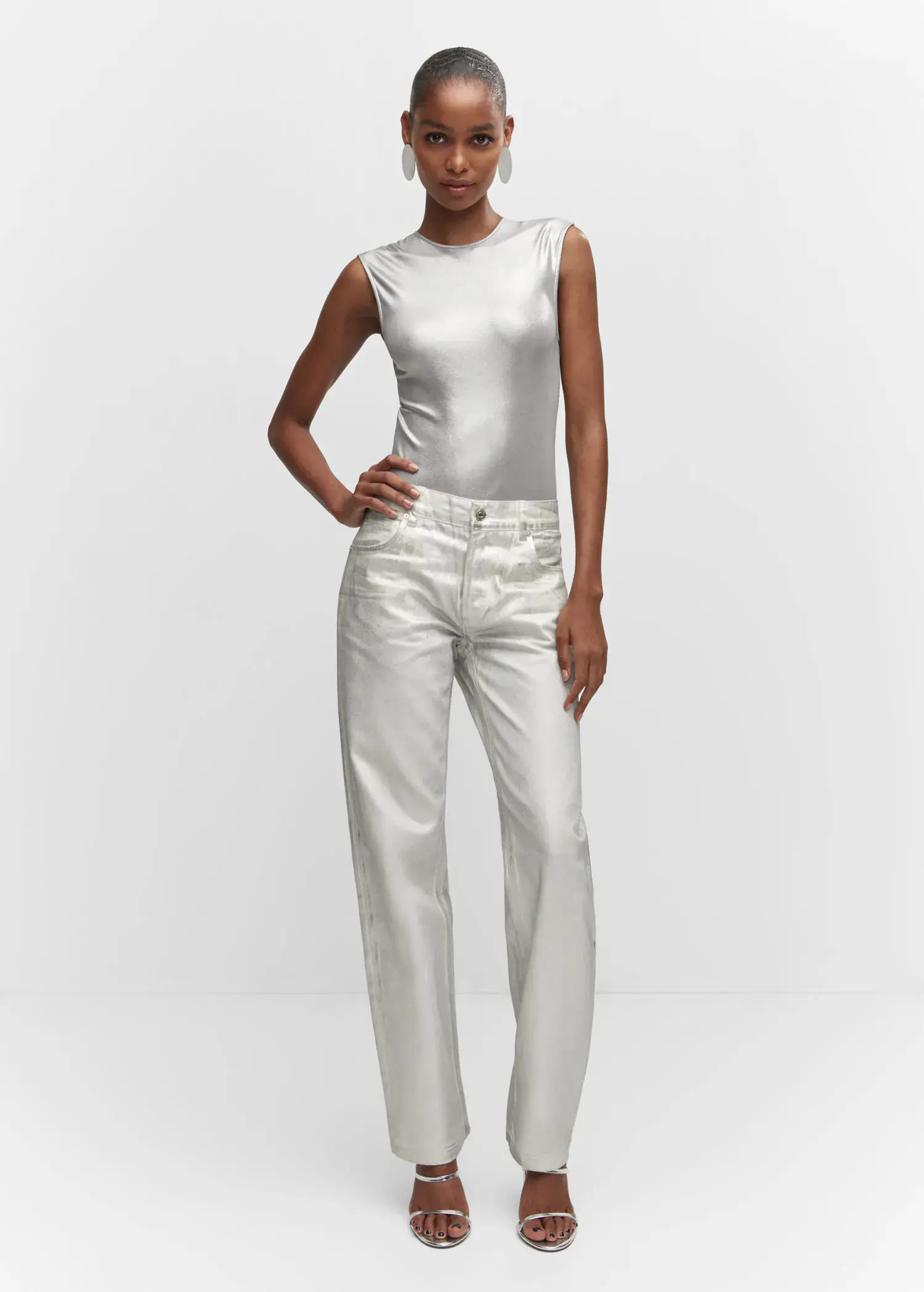 Mango Metallic bodysuit. a woman standing in front of a white background. 