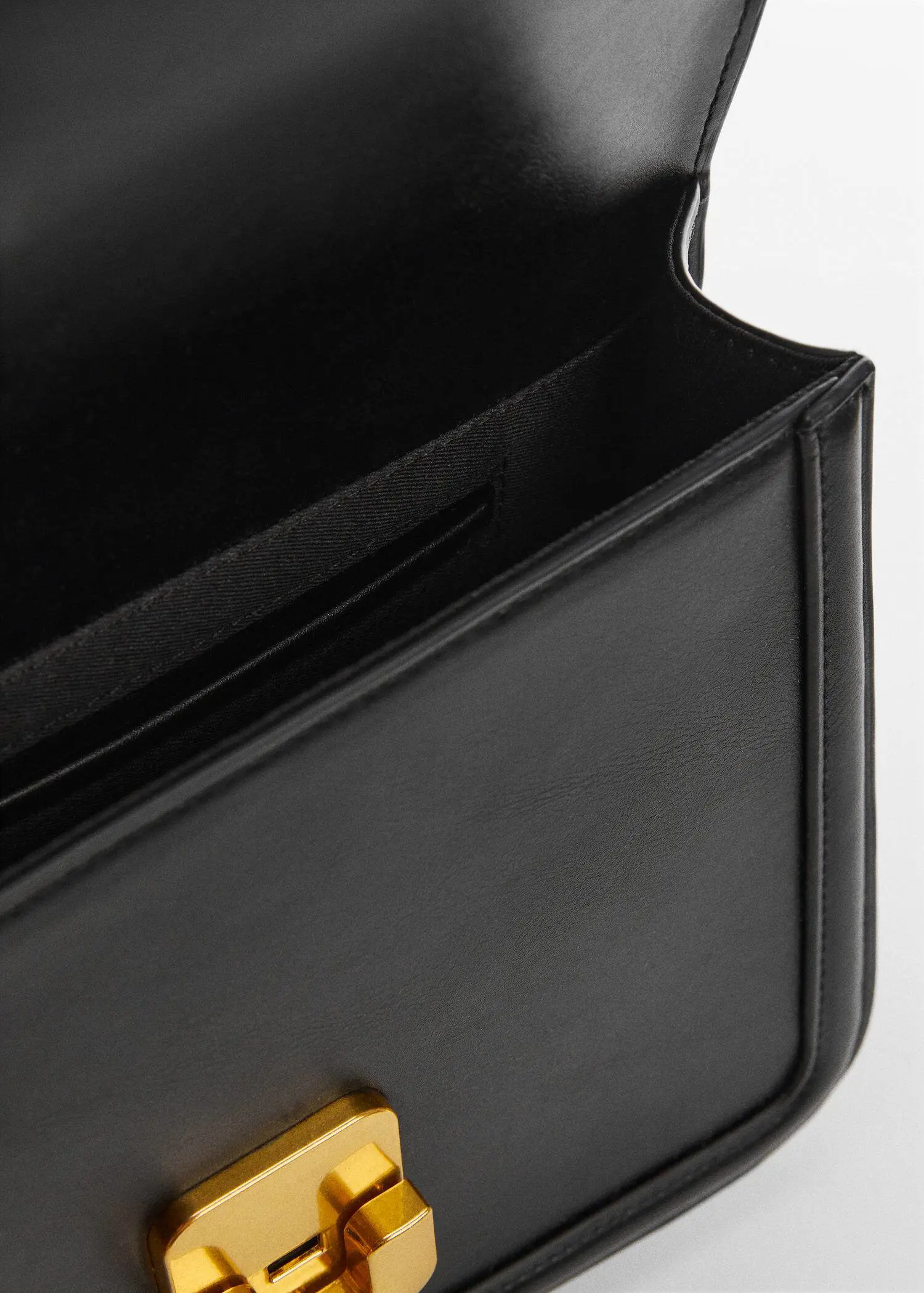 Mango Cross-body bag. a close-up view of the inside of a black purse. 