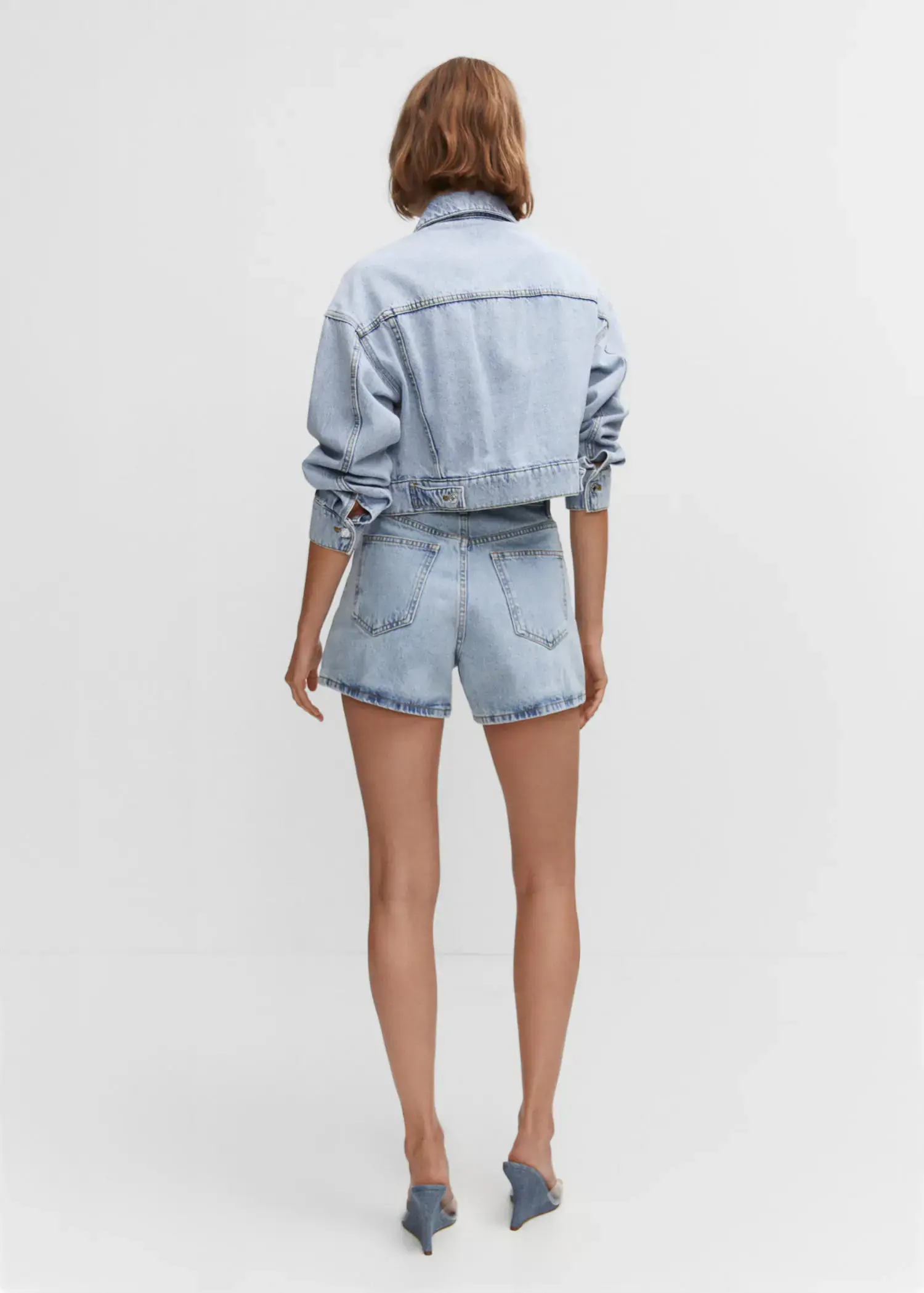 Mango High-rise denim shorts. a person wearing a jean jacket and shorts. 