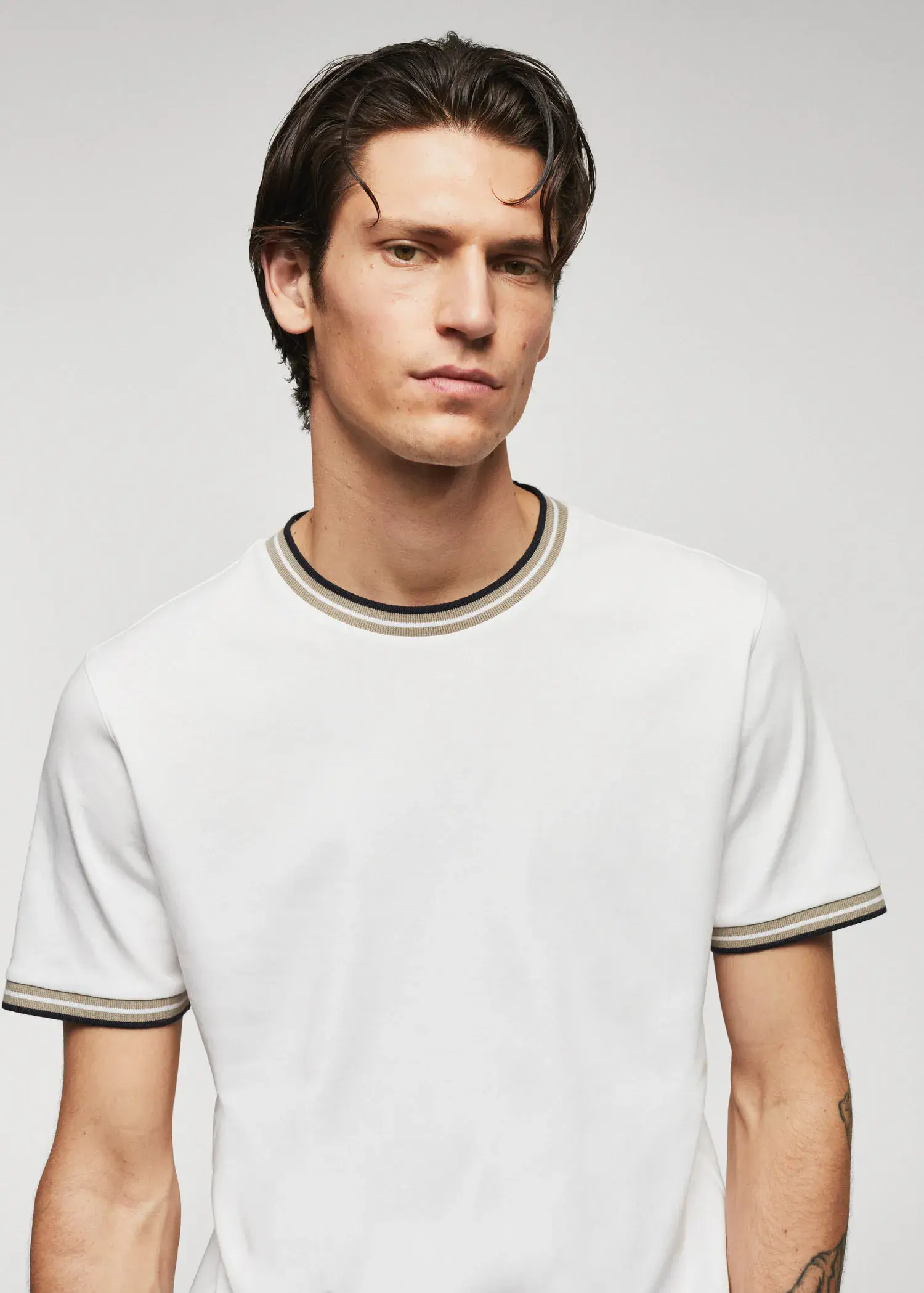 Mango 100% cotton t-shirt with contrast piping. a young man wearing a white t-shirt with a black and yellow trim around his neck. 