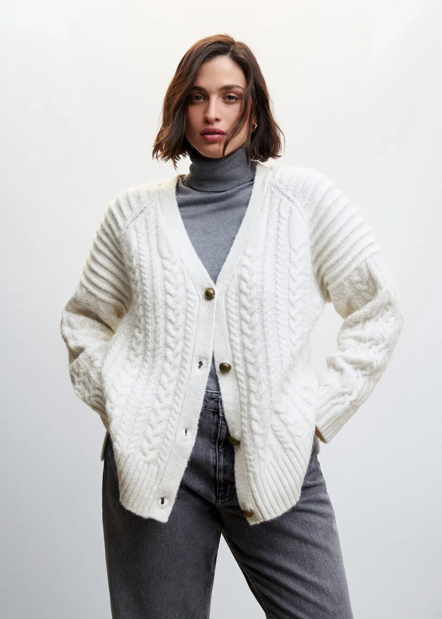 Mango Buttoned knit braided cardigan. a woman wearing a white sweater and jeans. 