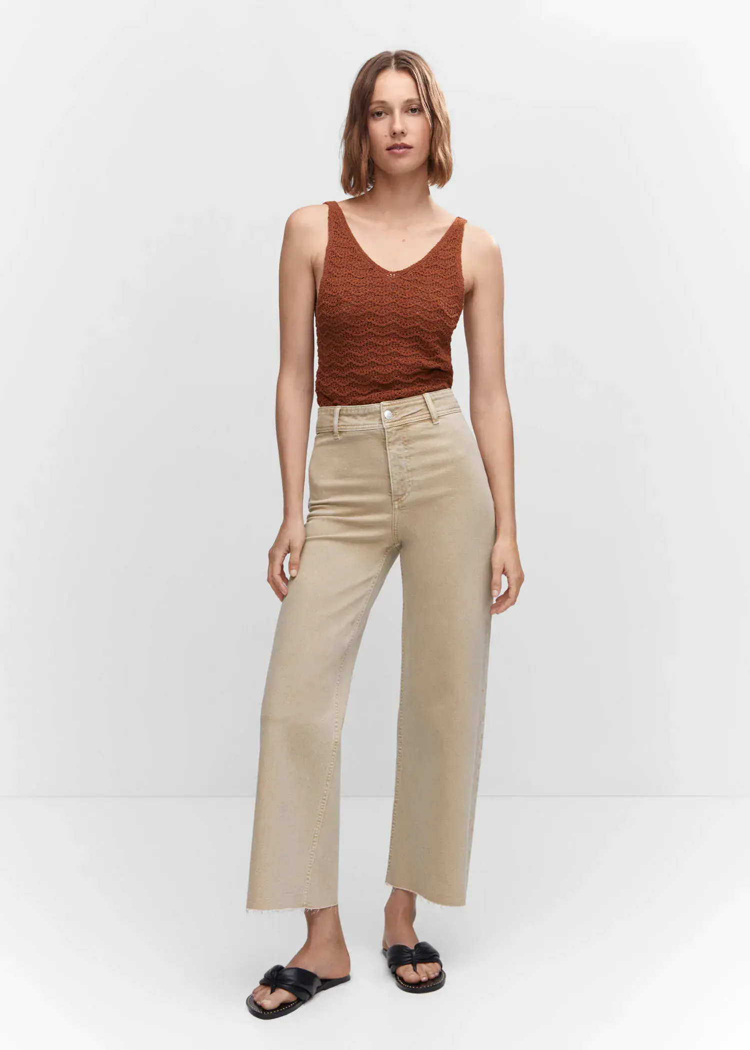 Mango Jeans culotte high waist. a woman standing in front of a white wall. 