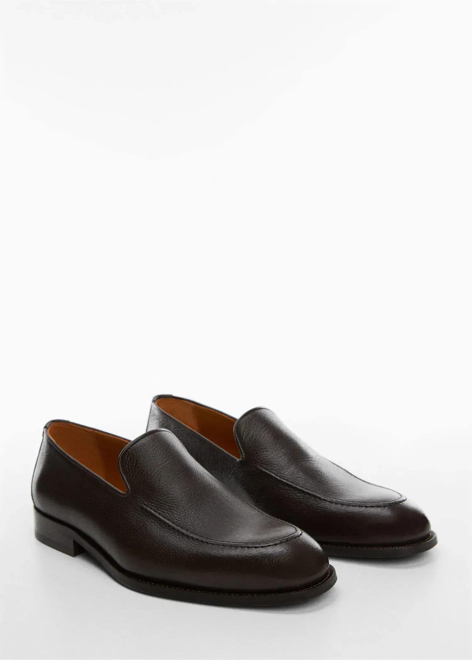 Mango Minimalist leather moccasins. a pair of black loafers on top of a white surface. 