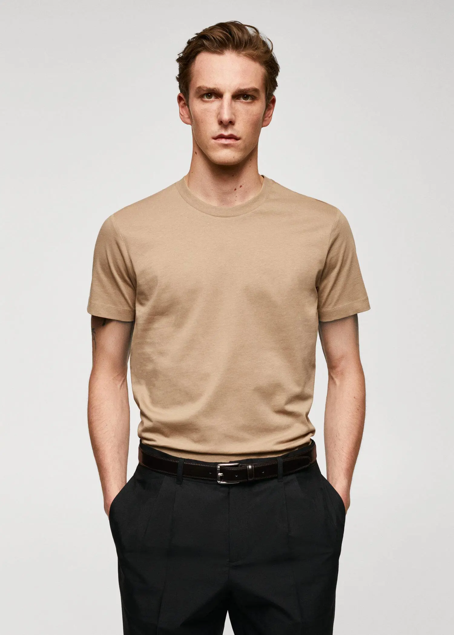 Mango Basic cotton stretch T-shirt. a man in a tan t-shirt is wearing a black belt. 