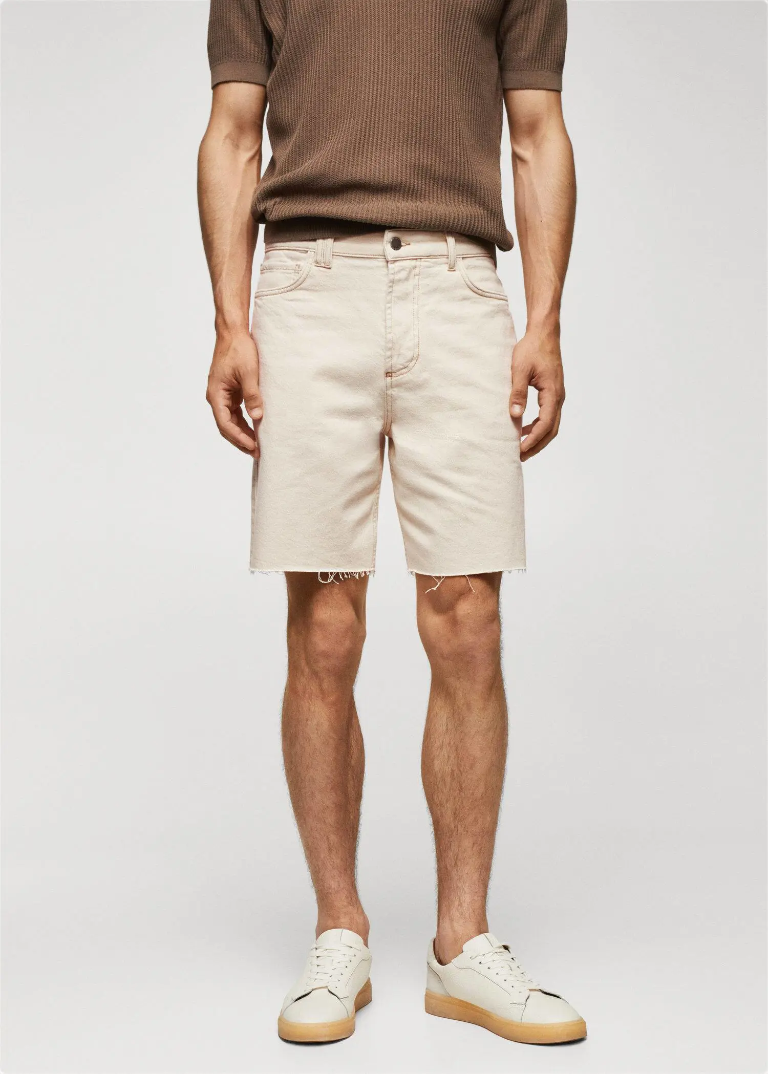 Mango Regular-fit denim bermuda shorts. a man wearing a pair of beige shorts. 