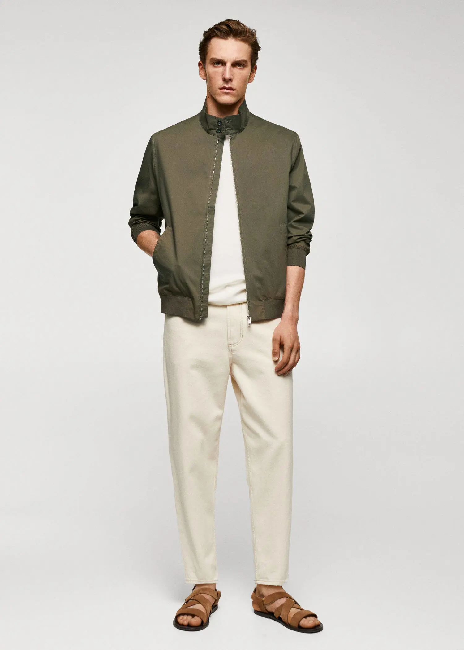Mango Lightweight fabric bomber jacket. a man wearing a green jacket and white pants. 