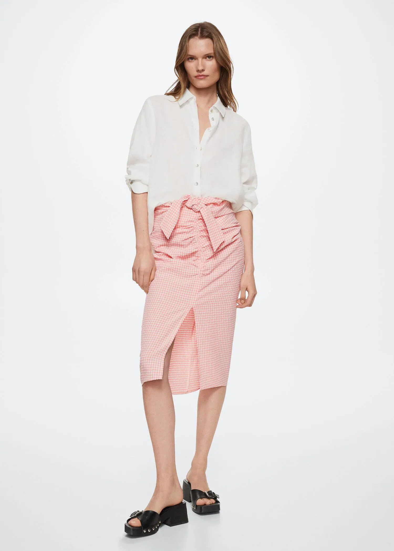 Mango Gingham pleated skirt. a woman wearing a white shirt and a pink skirt. 