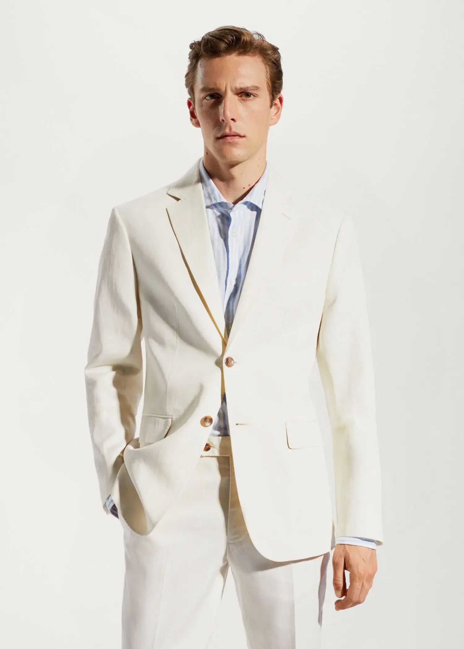Mango 100% linen suit blazer. a man in a white suit standing in front of a white wall. 