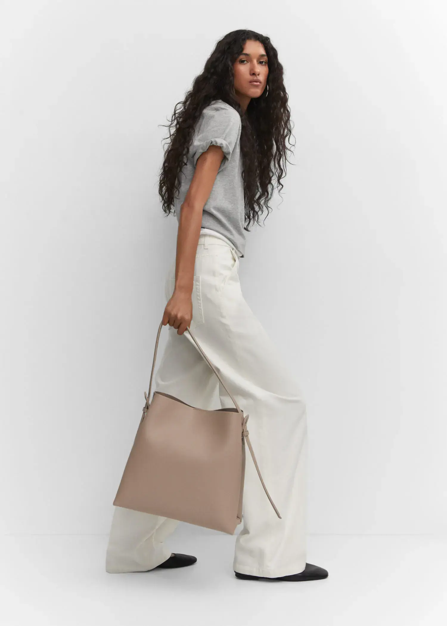 Mango Shopper bag with buckle. a woman holding onto a bag while standing up. 