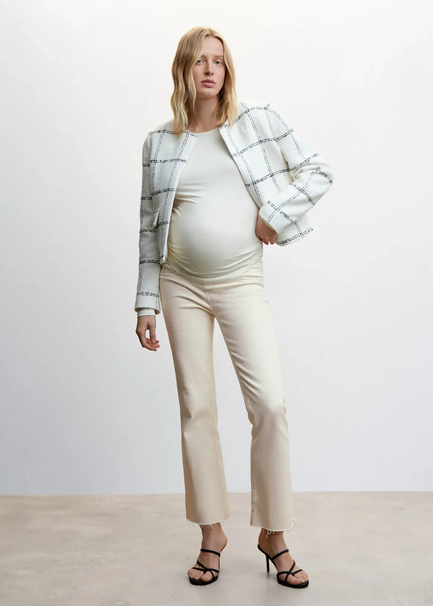 Mango Maternity flared cropped jeans. a pregnant woman wearing a white jacket. 