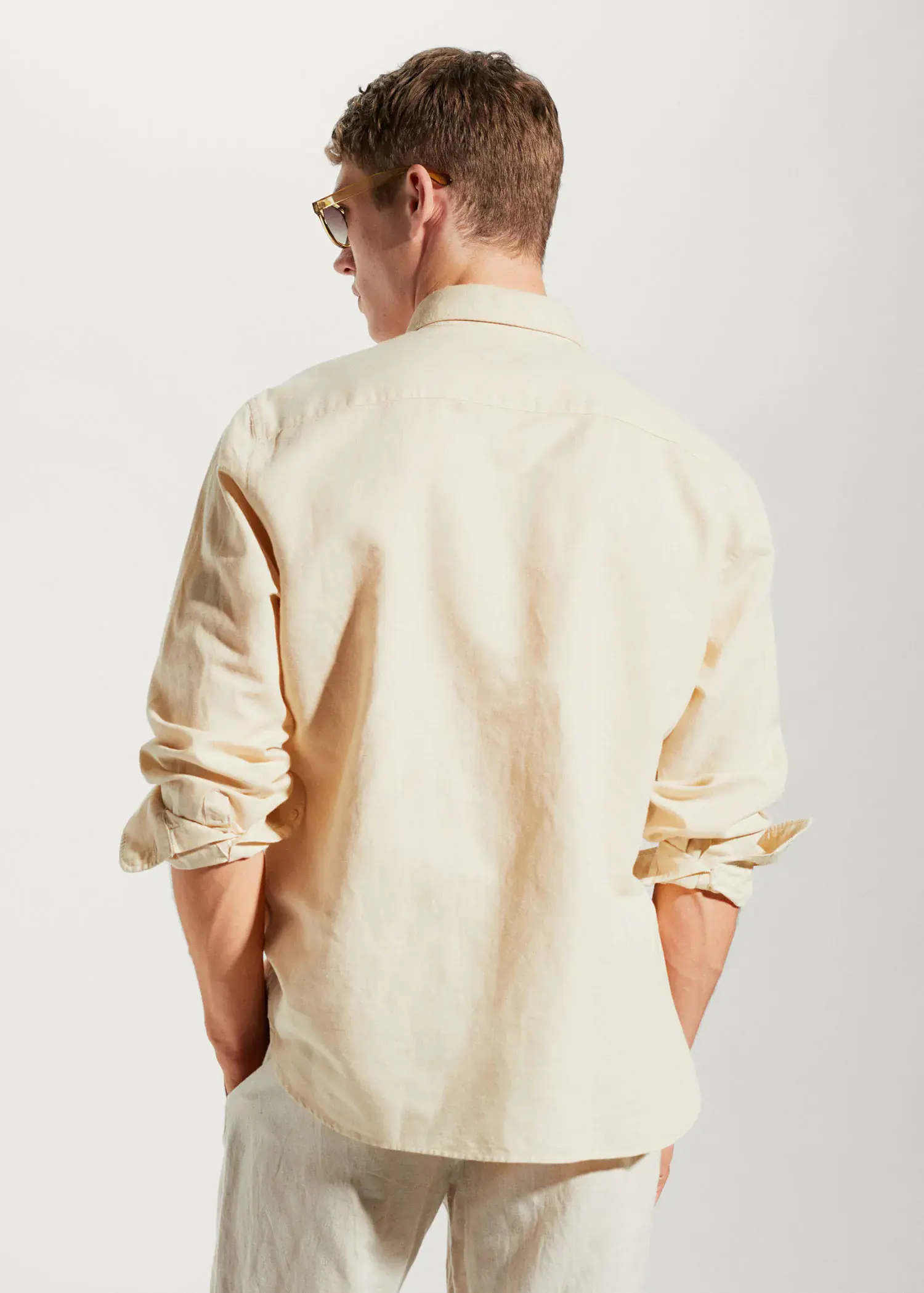 Mango Regular-fit linen cotton shirt. a man in a white shirt is standing with his back turned. 