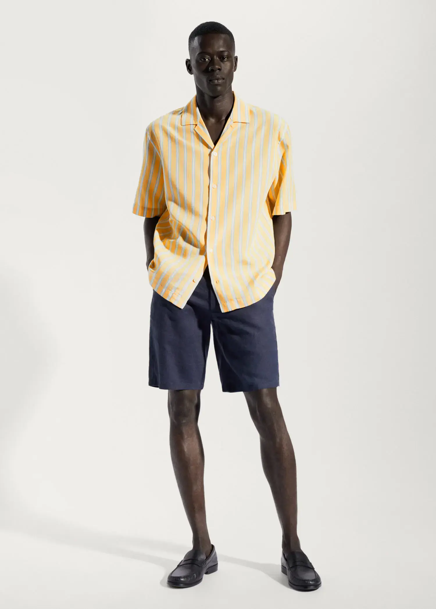 Mango Striped cotton linen shirt. a man wearing a yellow shirt and blue shorts. 