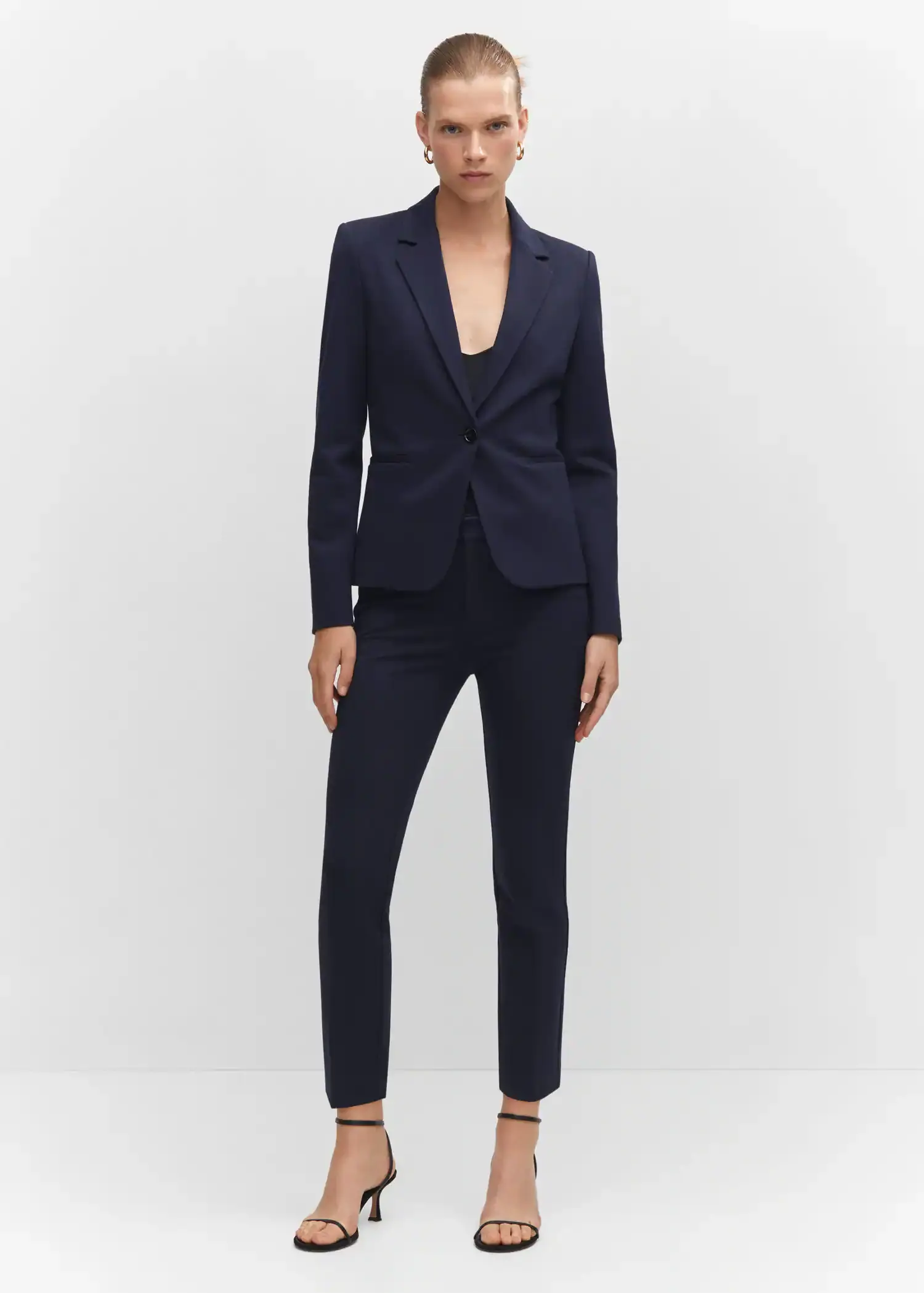 Mango Rome-knit straight pants. a woman wearing a suit standing in front of a white wall. 