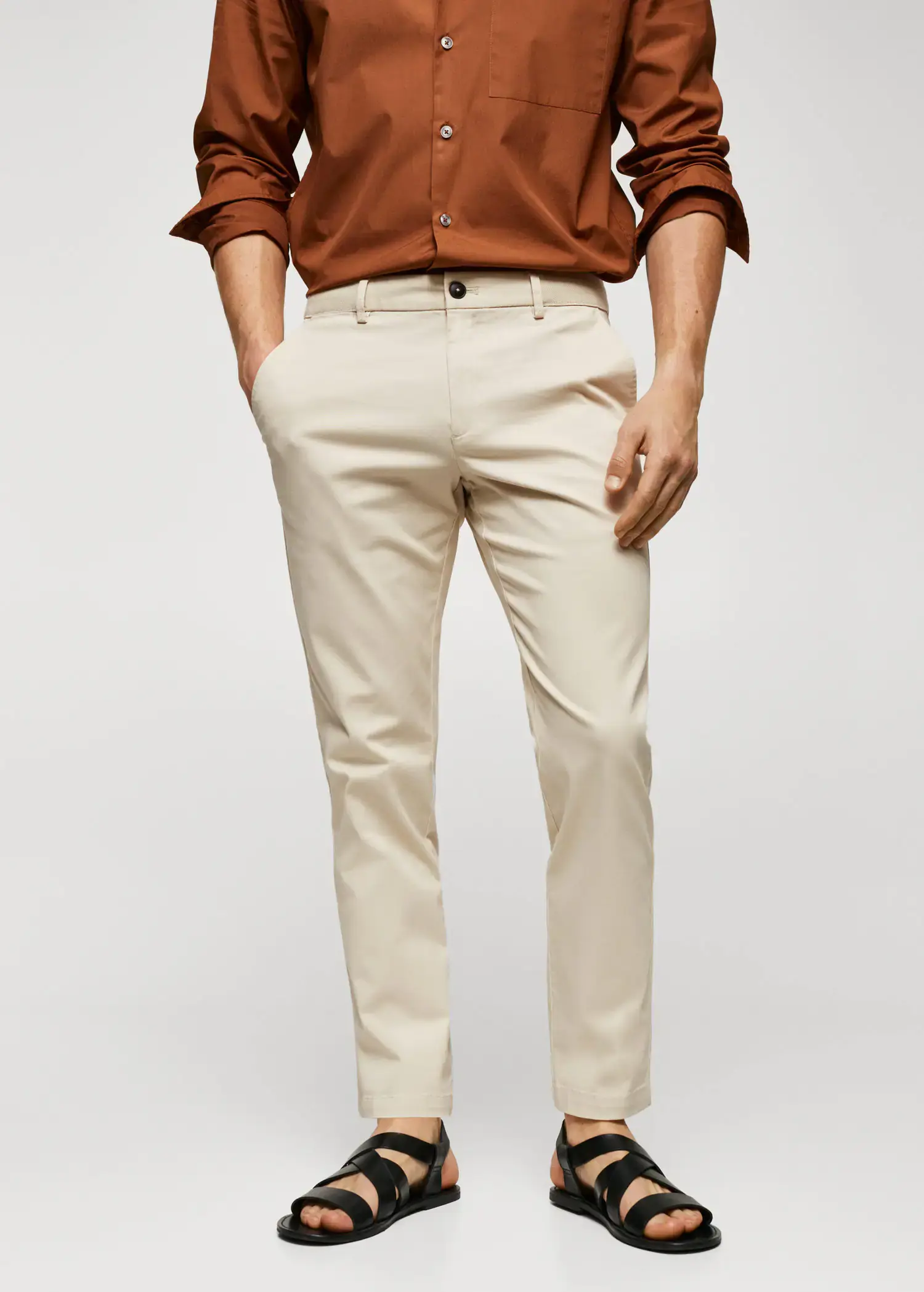 Mango Cotton tapered crop pants. a man in a brown shirt and beige pants. 