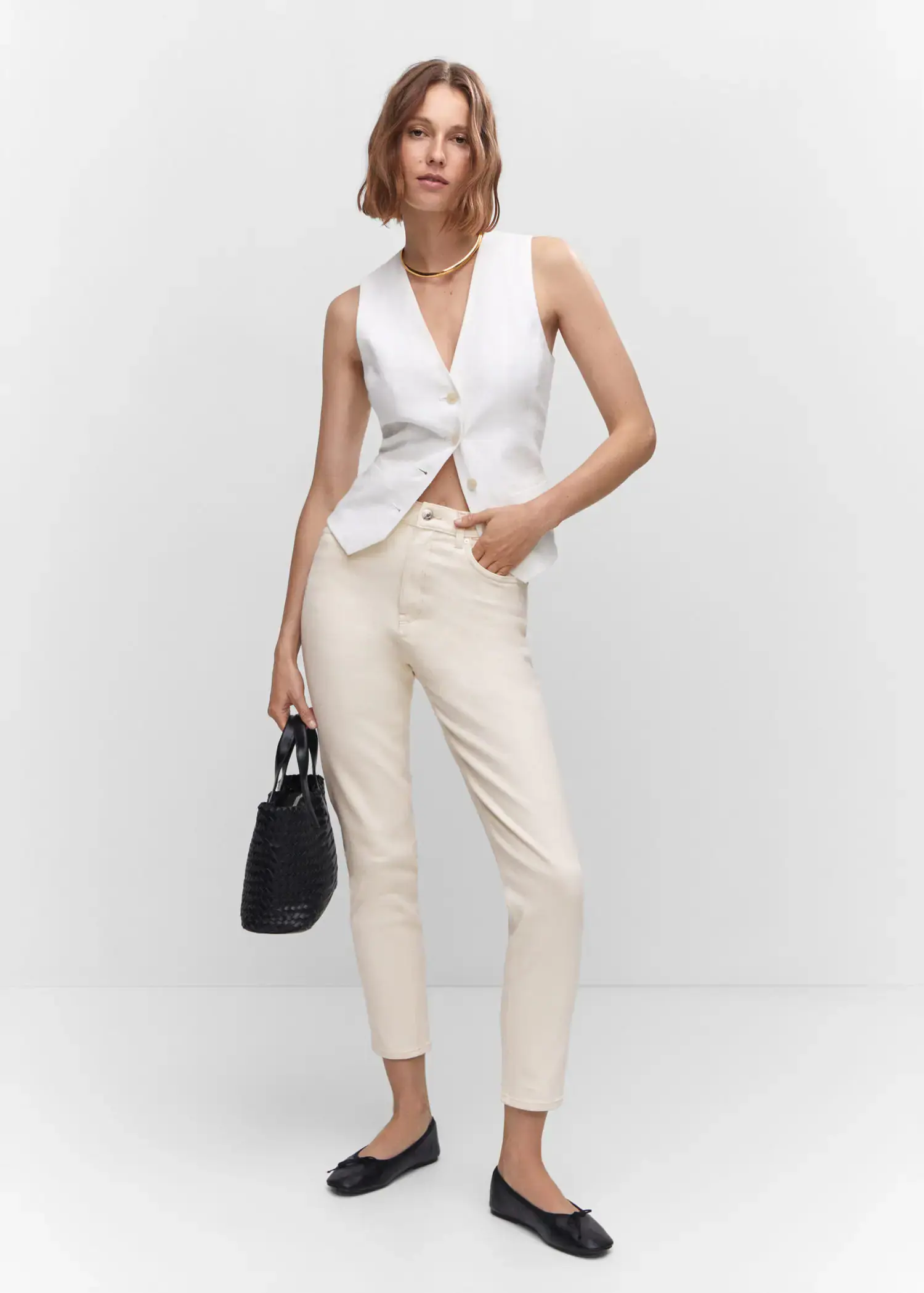 Mango Mom comfort high-rise jeans. a woman wearing a white vest and white pants. 