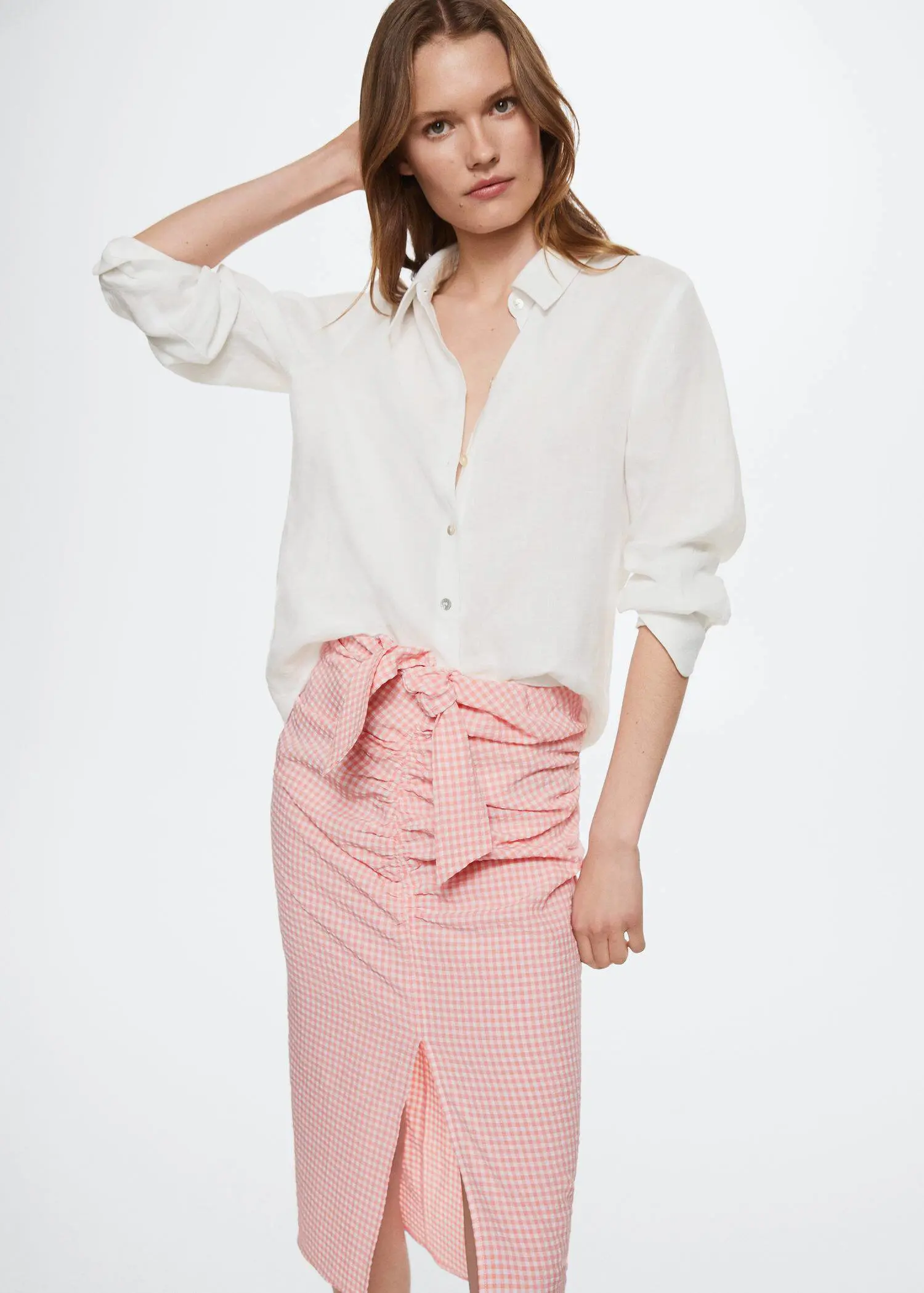 Mango Gingham pleated skirt. a woman wearing a white shirt and a pink skirt. 