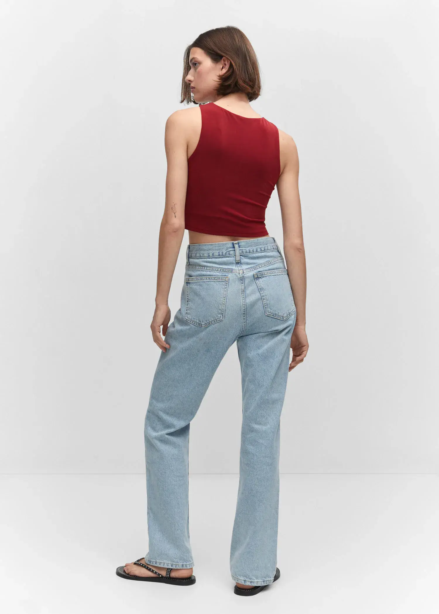 Mango Crop top halter neck. a woman in a red top and light blue jeans. 