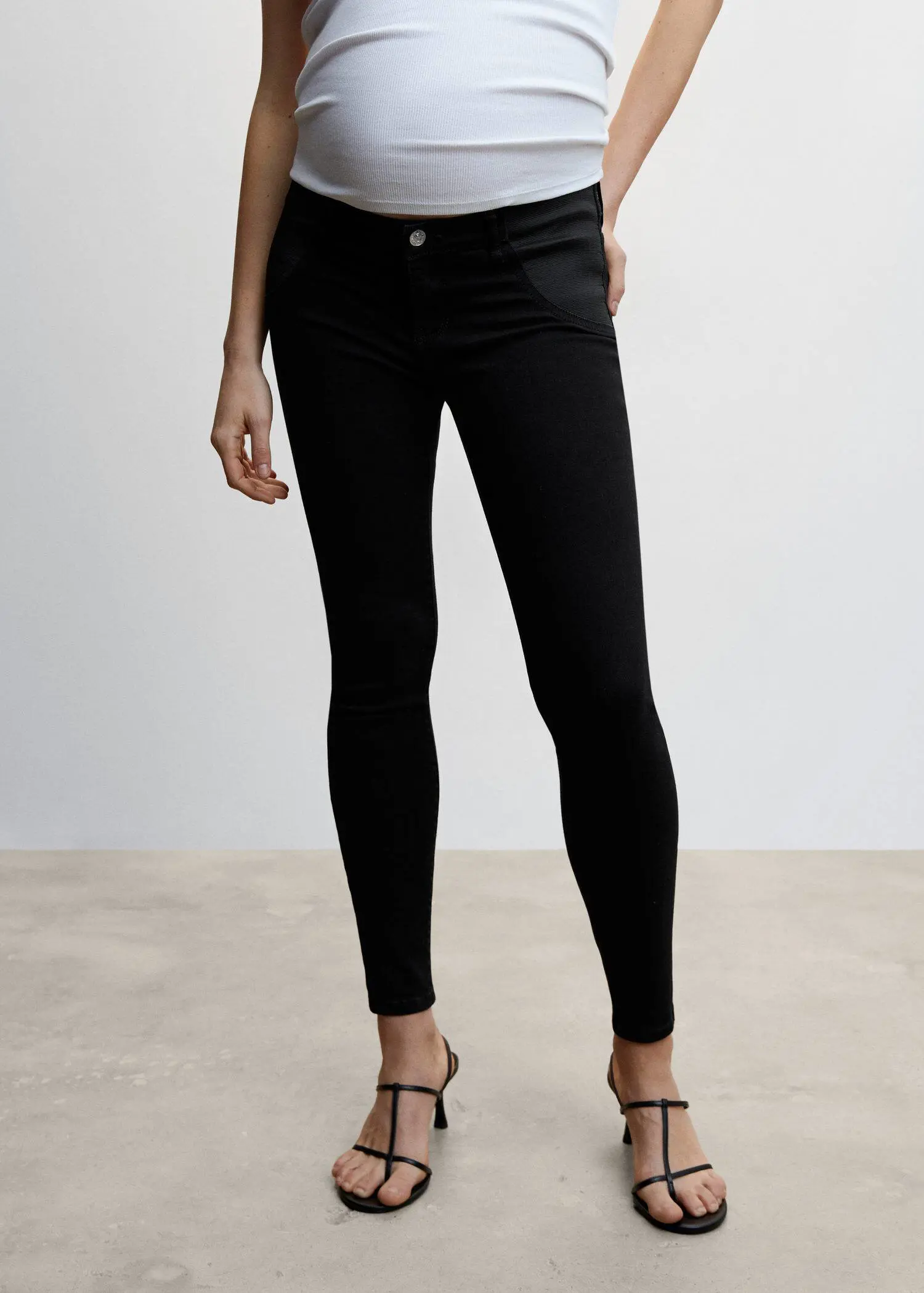 Mango Maternity skinny jeans. a woman wearing black pants and black shoes. 