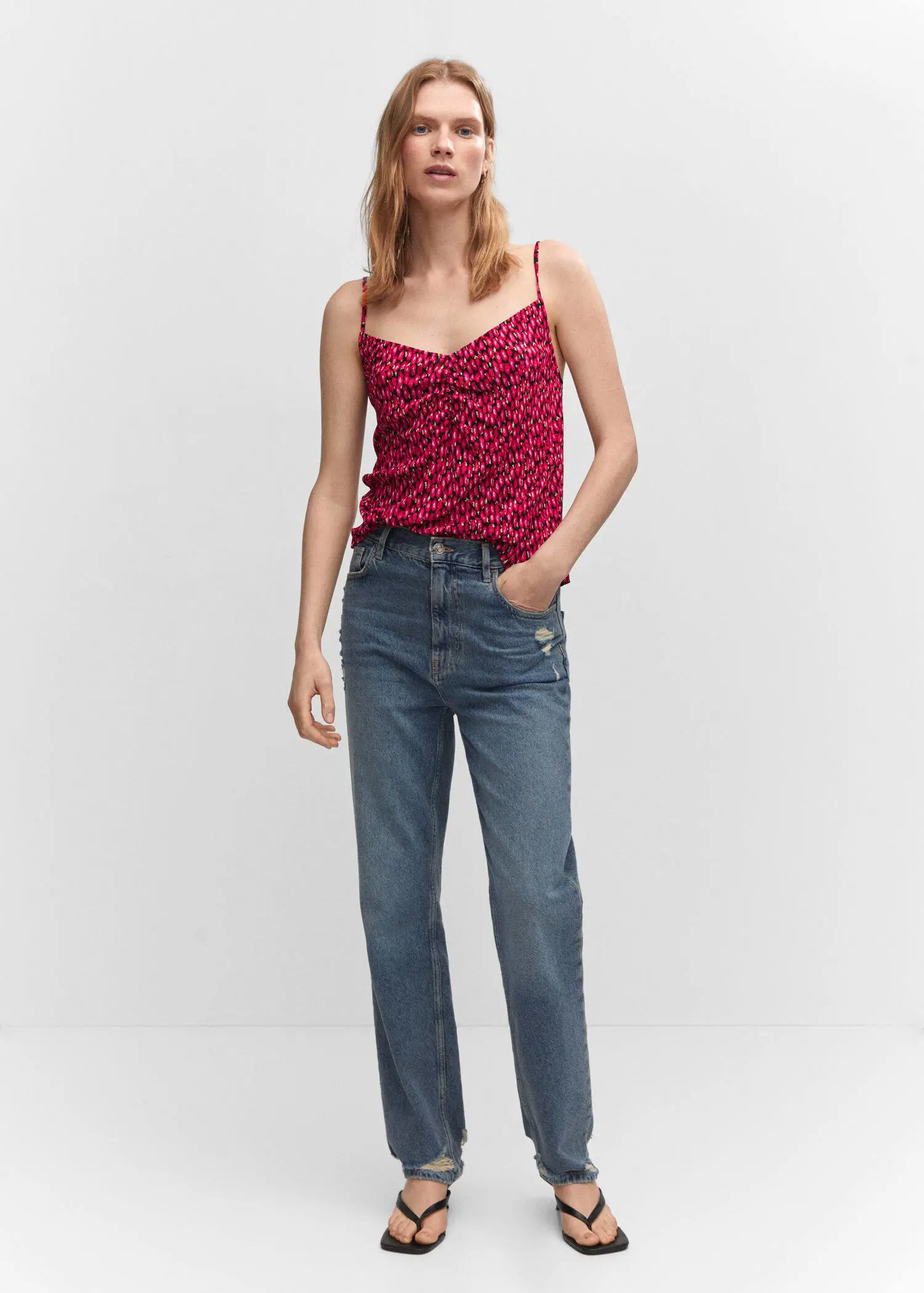 Mango Print ruched top. a woman in a red top and blue jeans. 