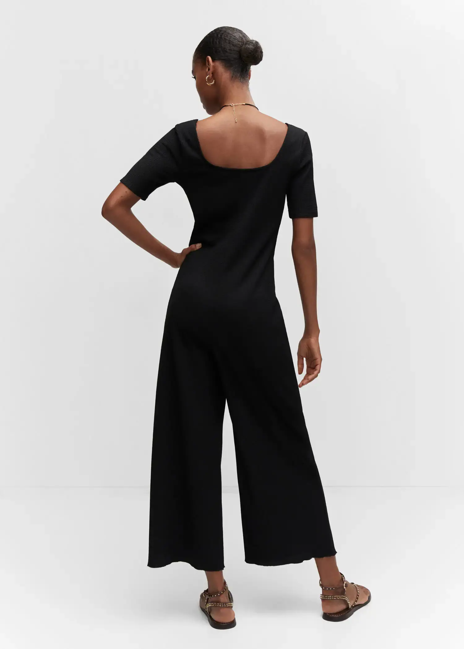 Mango Ruched long jumpsuit. a woman wearing a black jumpsuit is posing for a picture. 