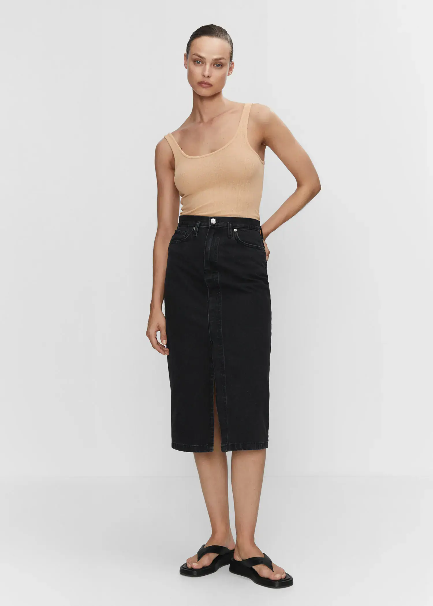 Mango Denim midi-skirt. a woman in a tan tank top and black skirt. 