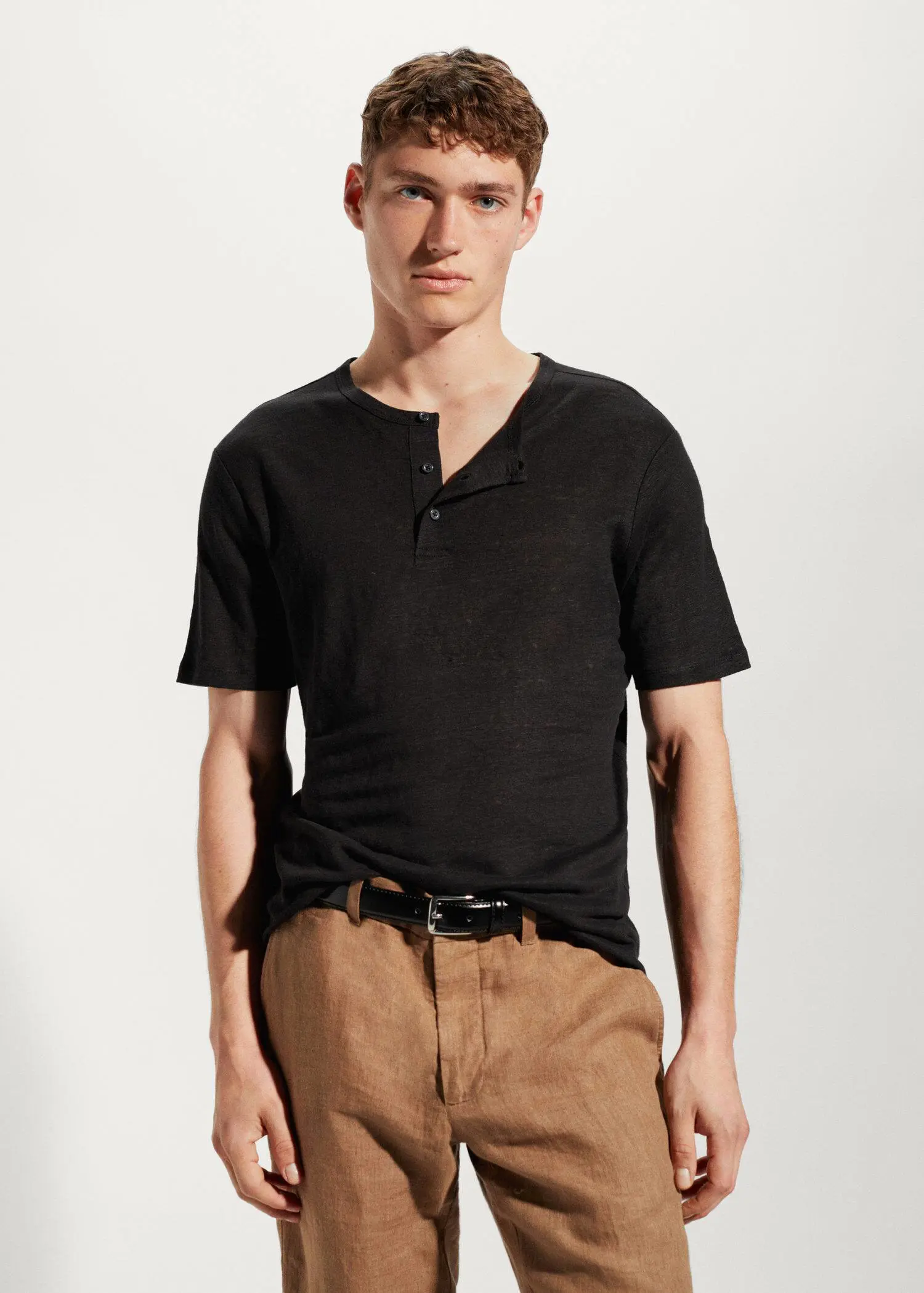 Mango 100% linen Henley t-shirt. a young man wearing a black shirt and brown pants. 