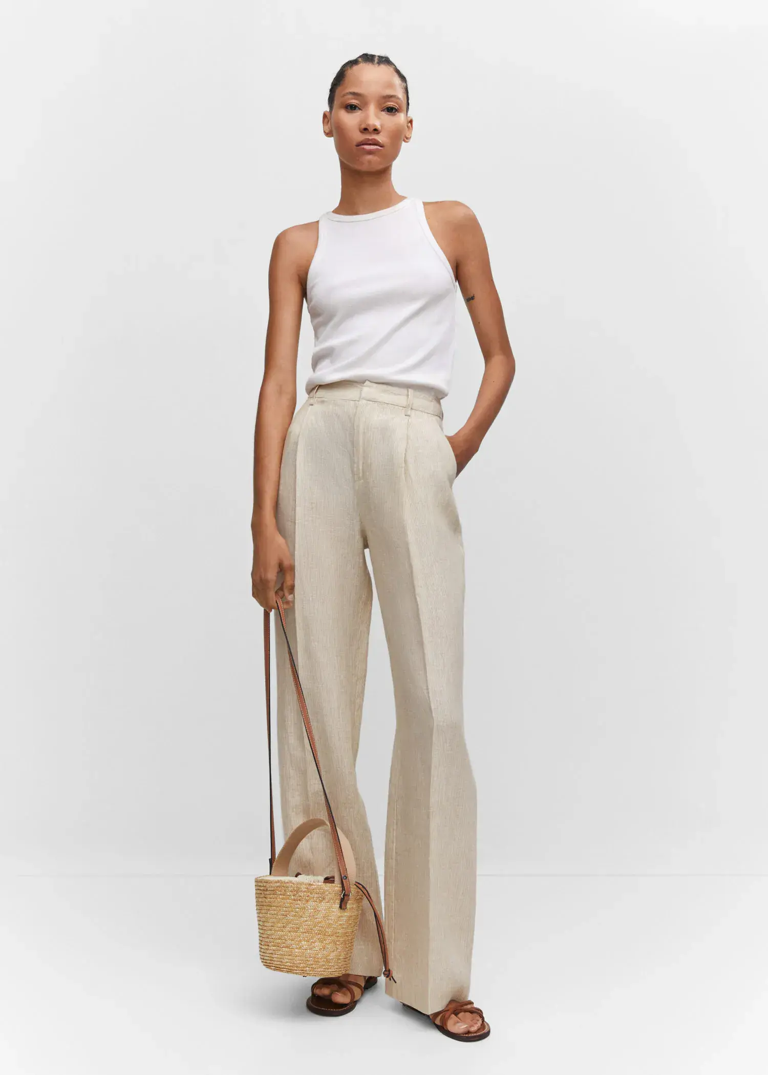 Mango Straight linen-blend pants. a woman standing in front of a white wall holding a purse. 
