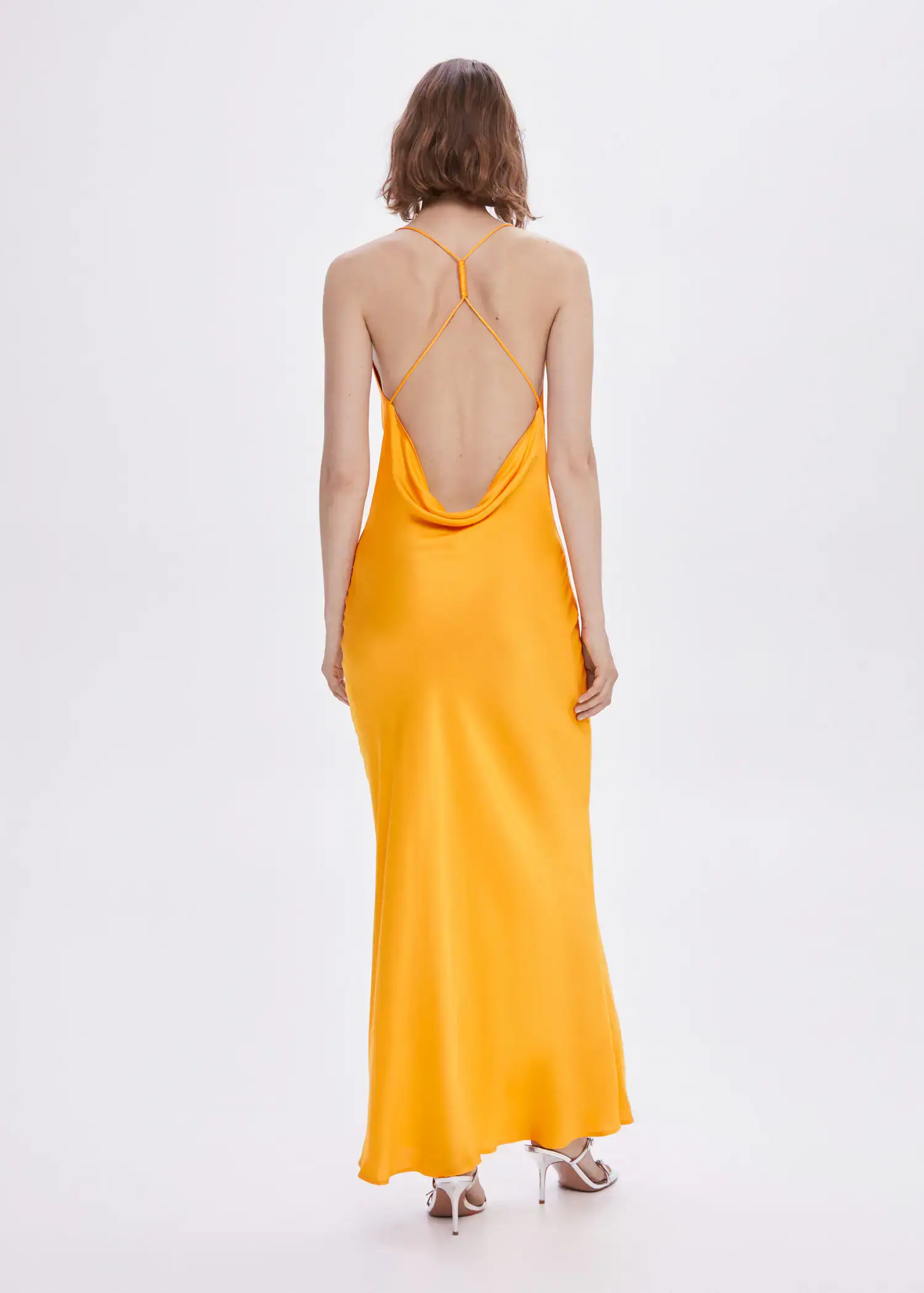 Mango Draped neck satin dress. a woman wearing a yellow dress standing in a room. 