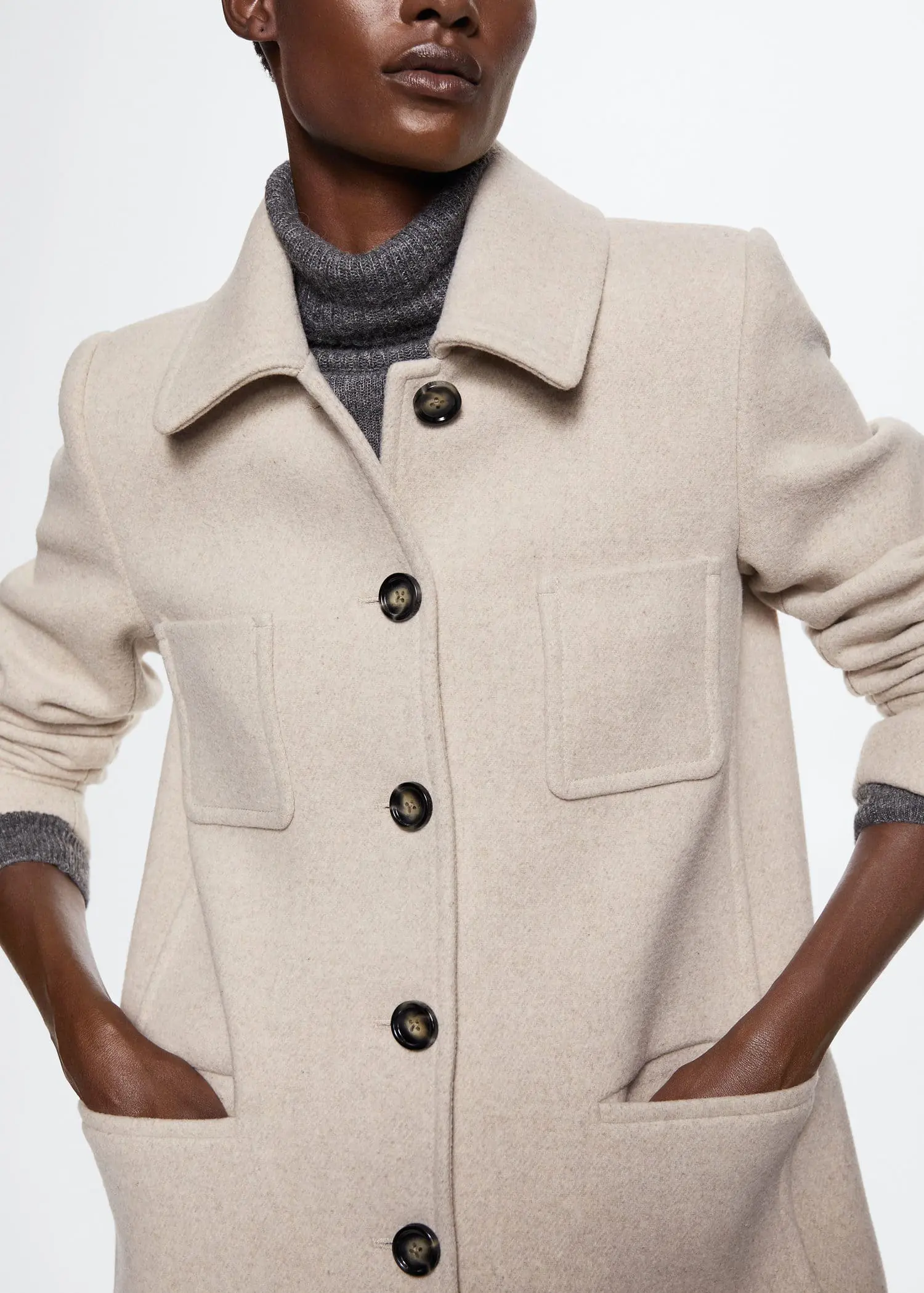 Mango Buttoned wool coat. a woman wearing a white coat with a gray sweater. 