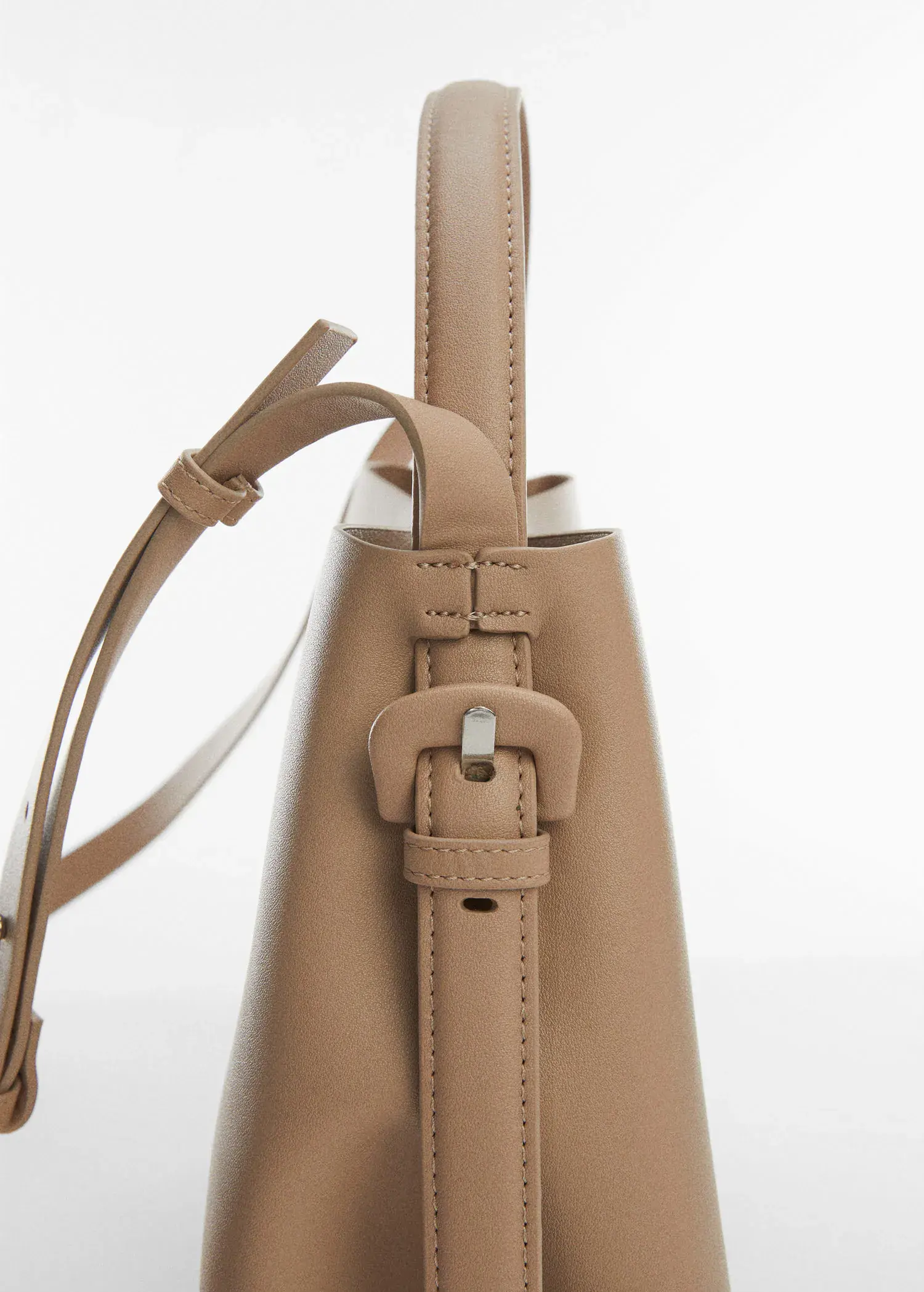 Mango Shopper bag with buckle. a close-up view of the strap of a purse. 