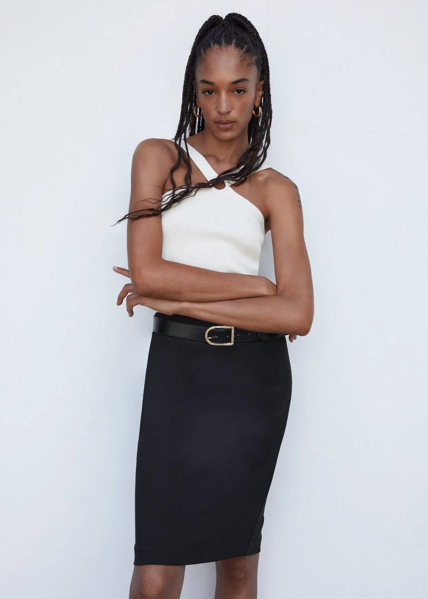 Mango Pencil skirt with Rome-knit opening. a woman in a white top and black skirt 