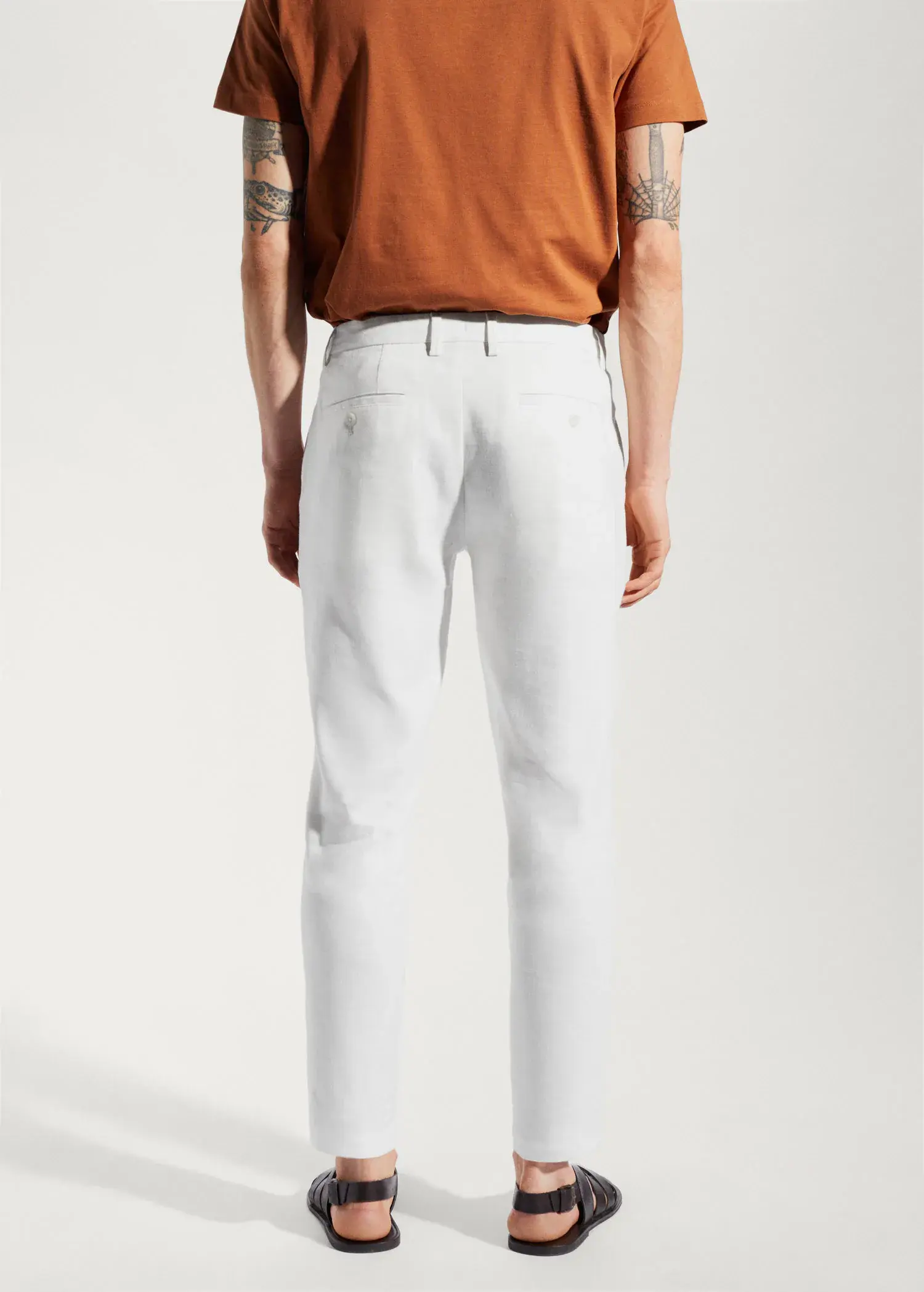Mango Linen slim-fit trousers with inner drawstring. a person wearing white pants and a brown shirt. 