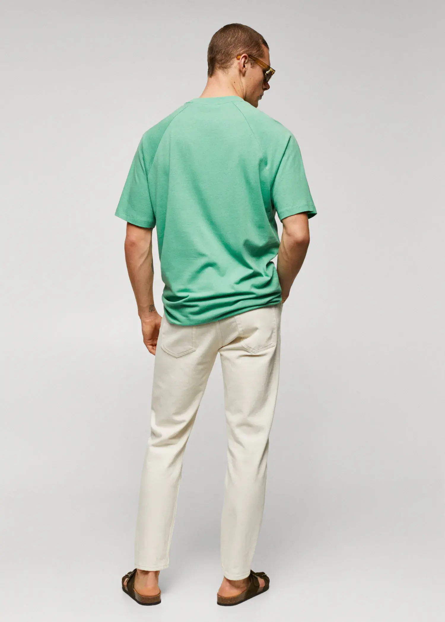 Mango Textured cotton-linen t-shirt. a man in a green shirt and white pants. 