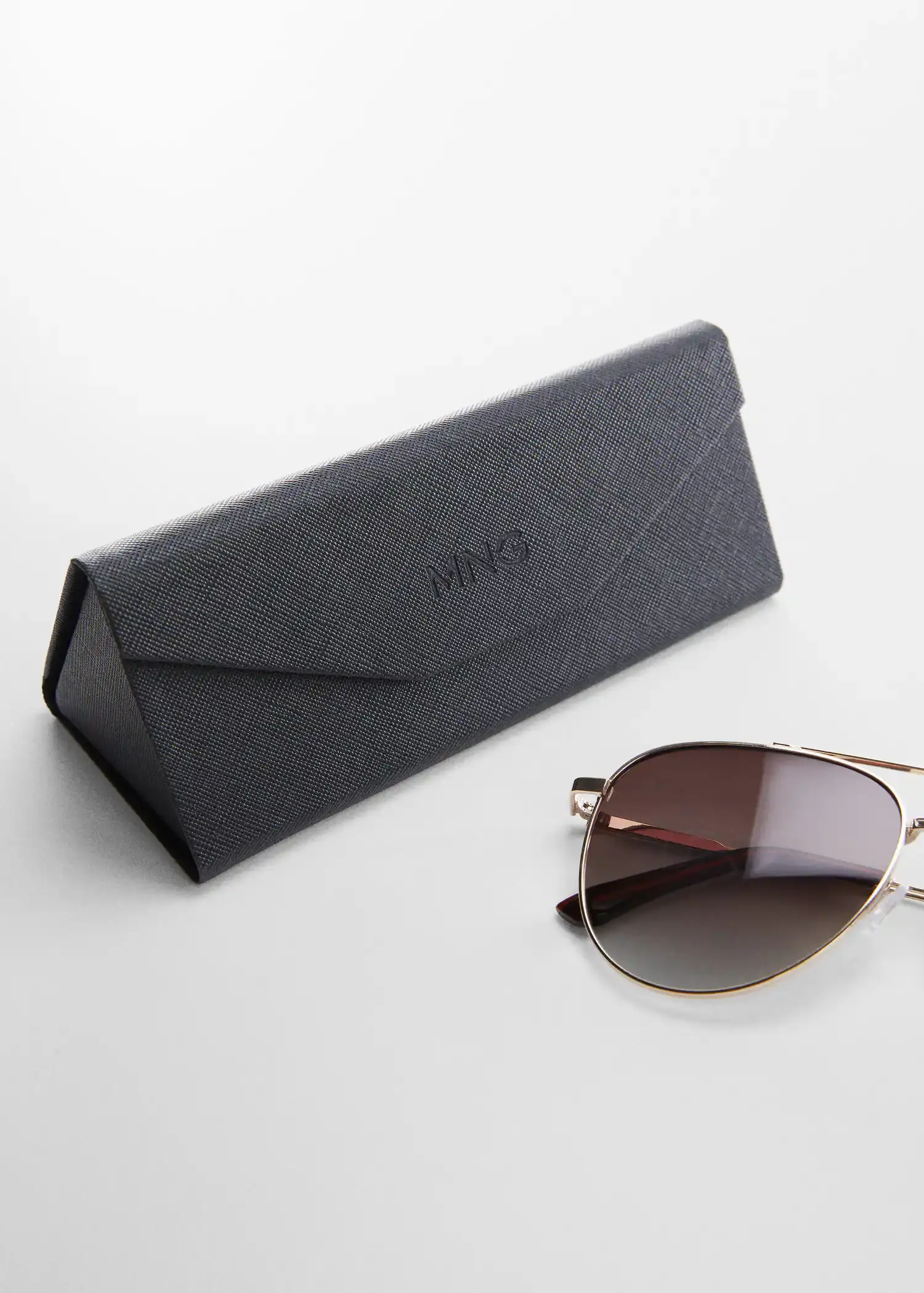 Mango Polarised sunglasses. a pair of sunglasses sitting on top of a table next to a case. 