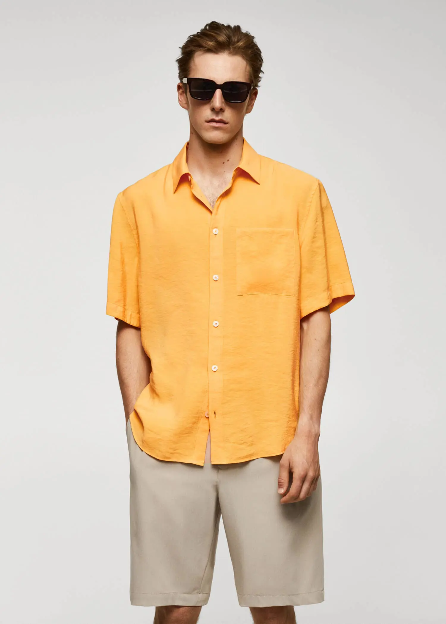 Mango Regular-fit short-sleeved shirt. a man wearing a yellow shirt and sunglasses. 
