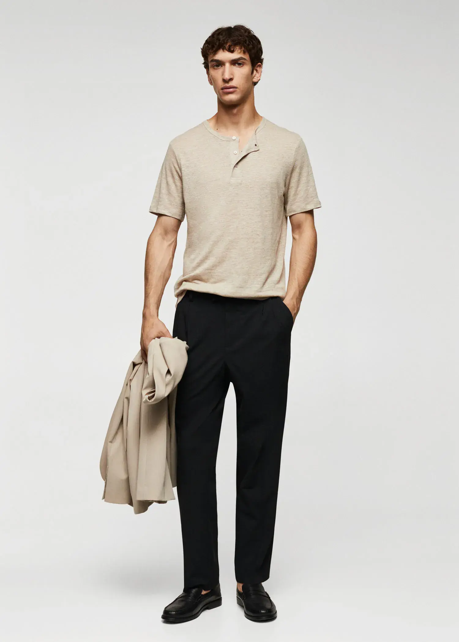 Mango Regular fit pleated cotton trousers. a man in a tan shirt and black pants. 