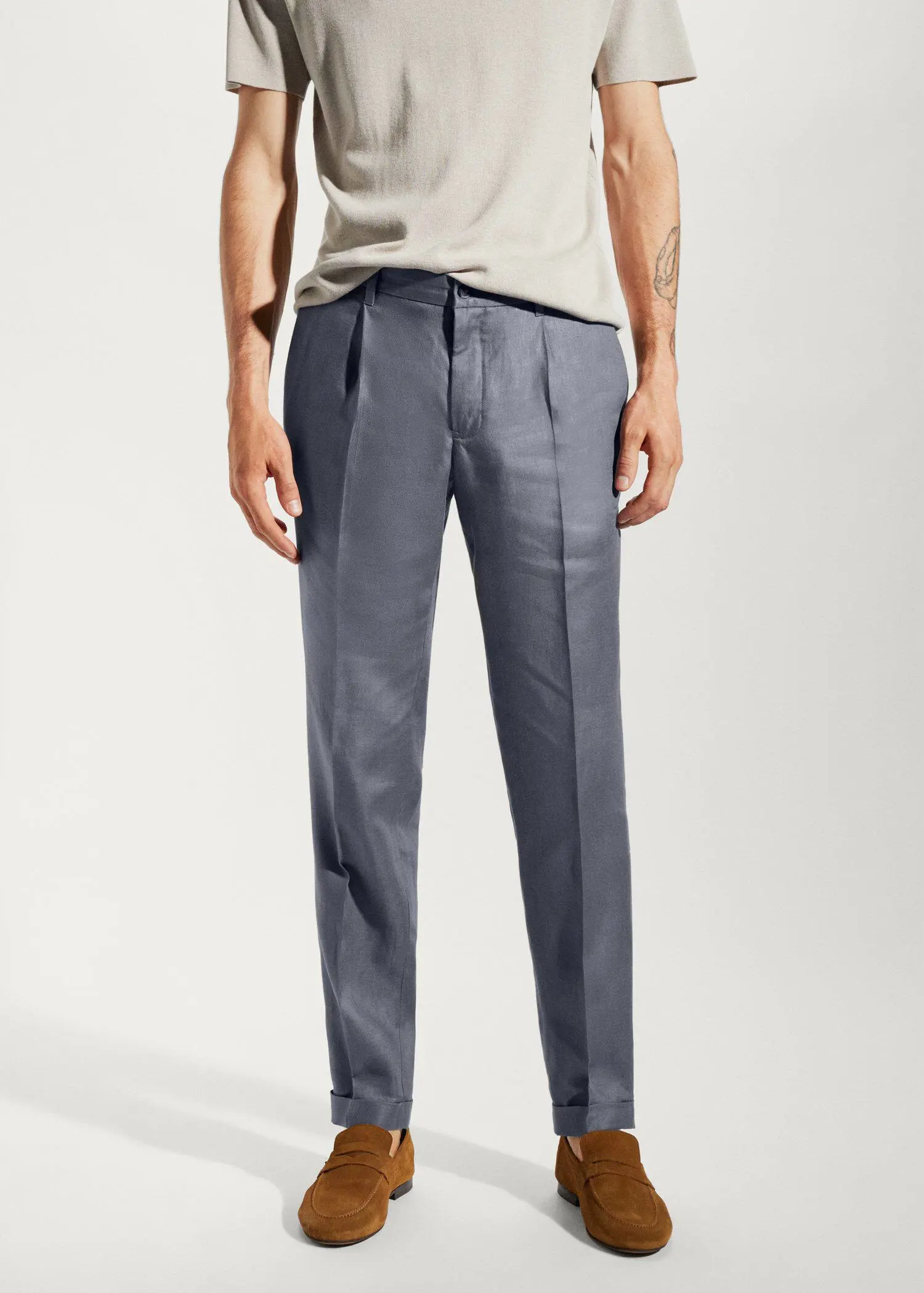 Mango 100% linen regular-fit pants. a man standing in front of a white wall. 