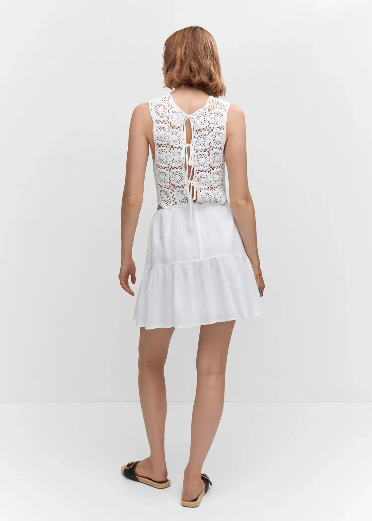 Mango Crochet dress with openings. a woman wearing a white dress standing in front of a white wall. 