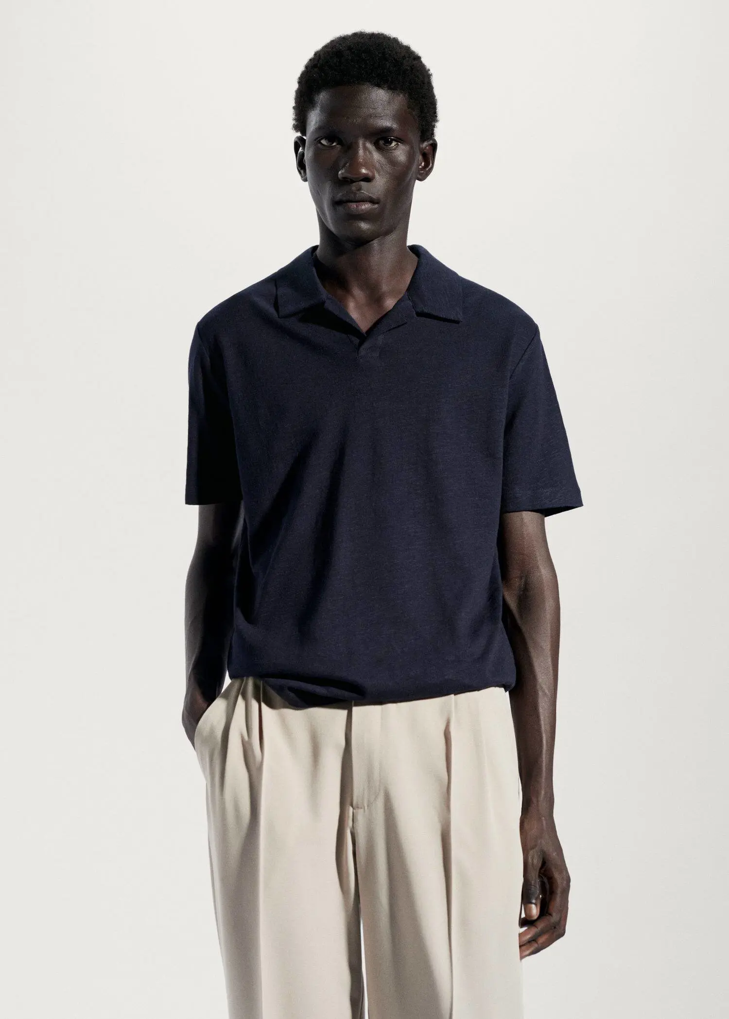 Mango Cotton linen slim-fit polo shirt. a man in a black shirt and beige pants. 