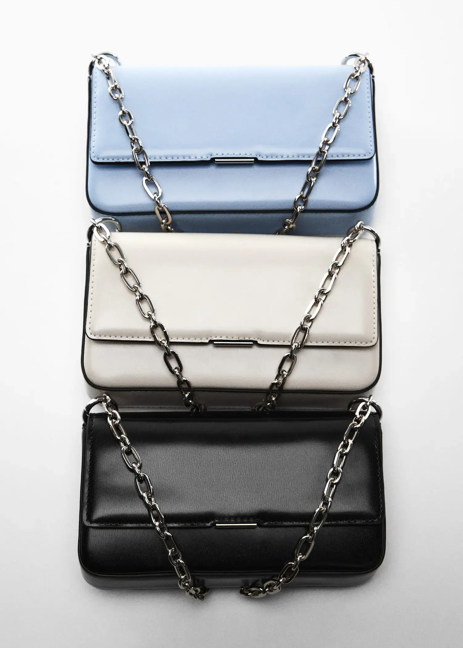 Mango Flap chain bag. a group of three purses sitting next to each other on a table. 